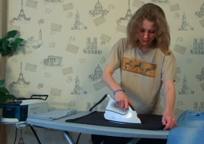 young-woman-ironing-her-shirt-with-modern-iron-slider_nj0fvpkul__F0011
